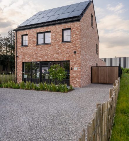 Afgewerkte nieuwbouwwoning met gevel in baksteen en zonnepanelen