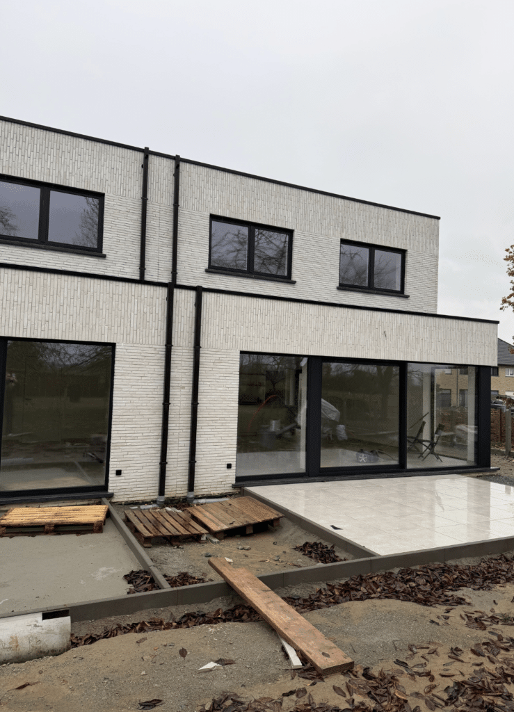 Moderne kubusvormige nieuwbouw woning in de afbouwfase met grote raampartijen