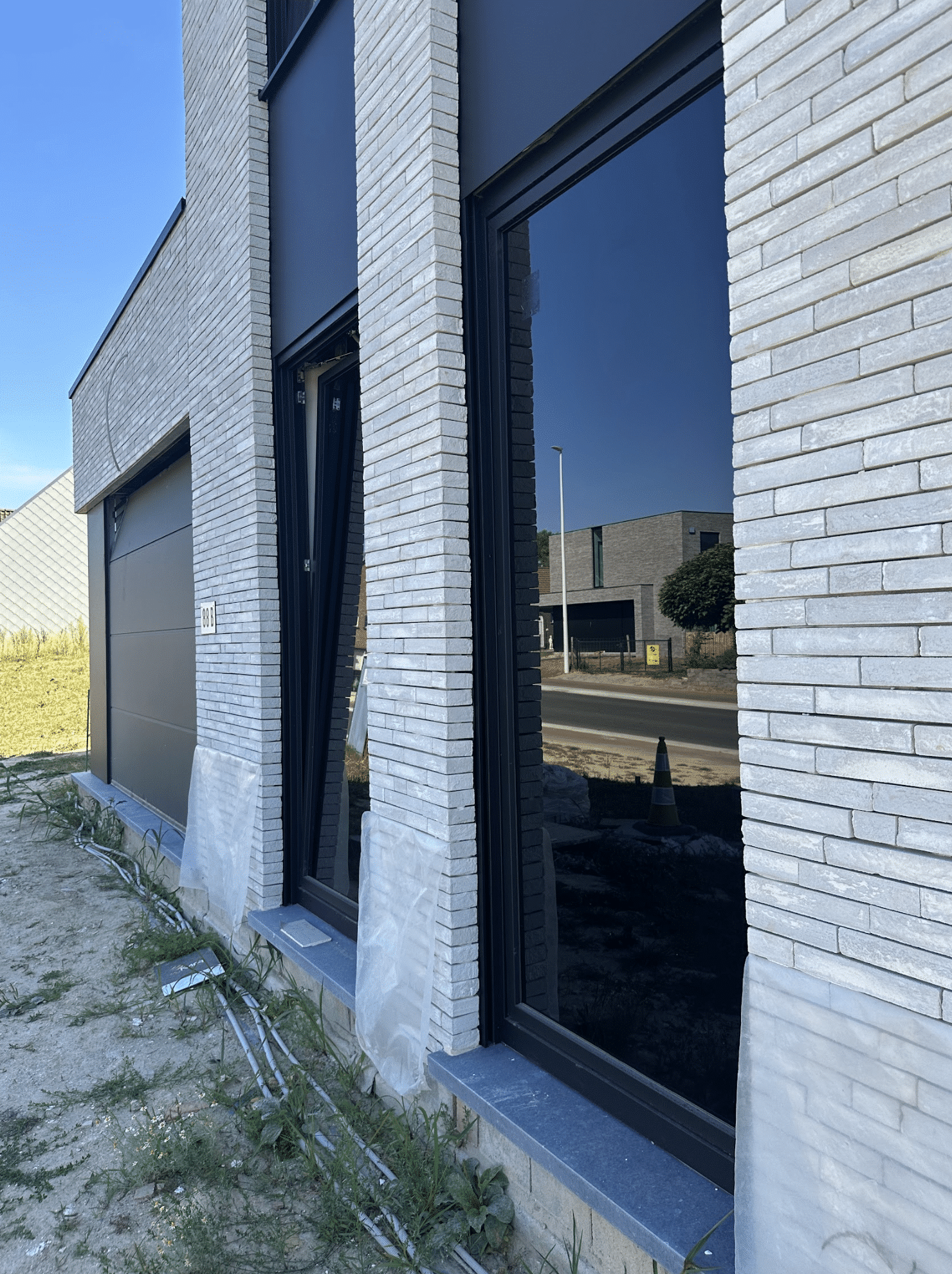 Casco woning met geplaatste ramen en afgewerkte buitenschil, wind- en waterdicht.