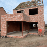 Ruwbouw woning in opbouwfase met zichtbare structuur en dakconstructie.