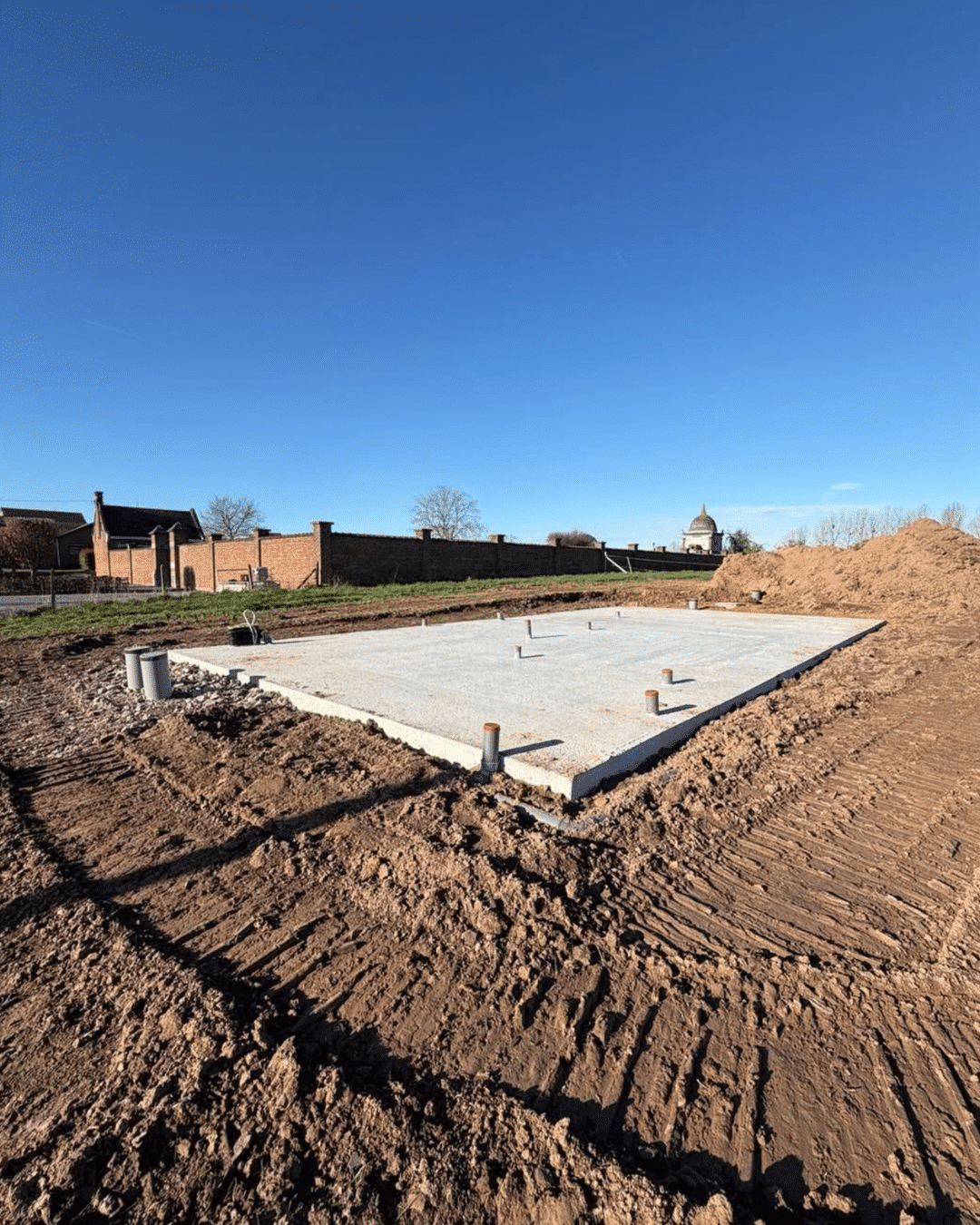 Start van ruwbouw met funderingsplaat als basis van de woning.
