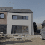 Compacte nieuwbouwwoning met strakke gevelsteen en grote raampartijen in de eindfase van de bouw.