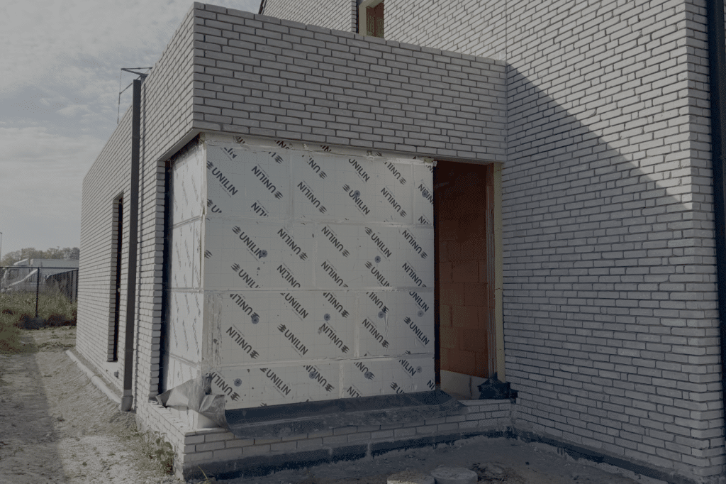 Nieuwbouwwoning in opbouw met zichtbare isolatieplaten van Unilin aangebracht op de gevel.
