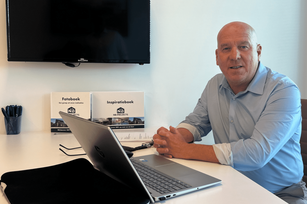 Een adviseur van NB-Projects zit klaar voor een gesprek met het fotoboek en inspiratieboek op tafel.
