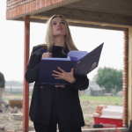 Een bouwcoördinator van NB-Projects inspecteert de werf en noteert observaties in haar bouwdossier.
