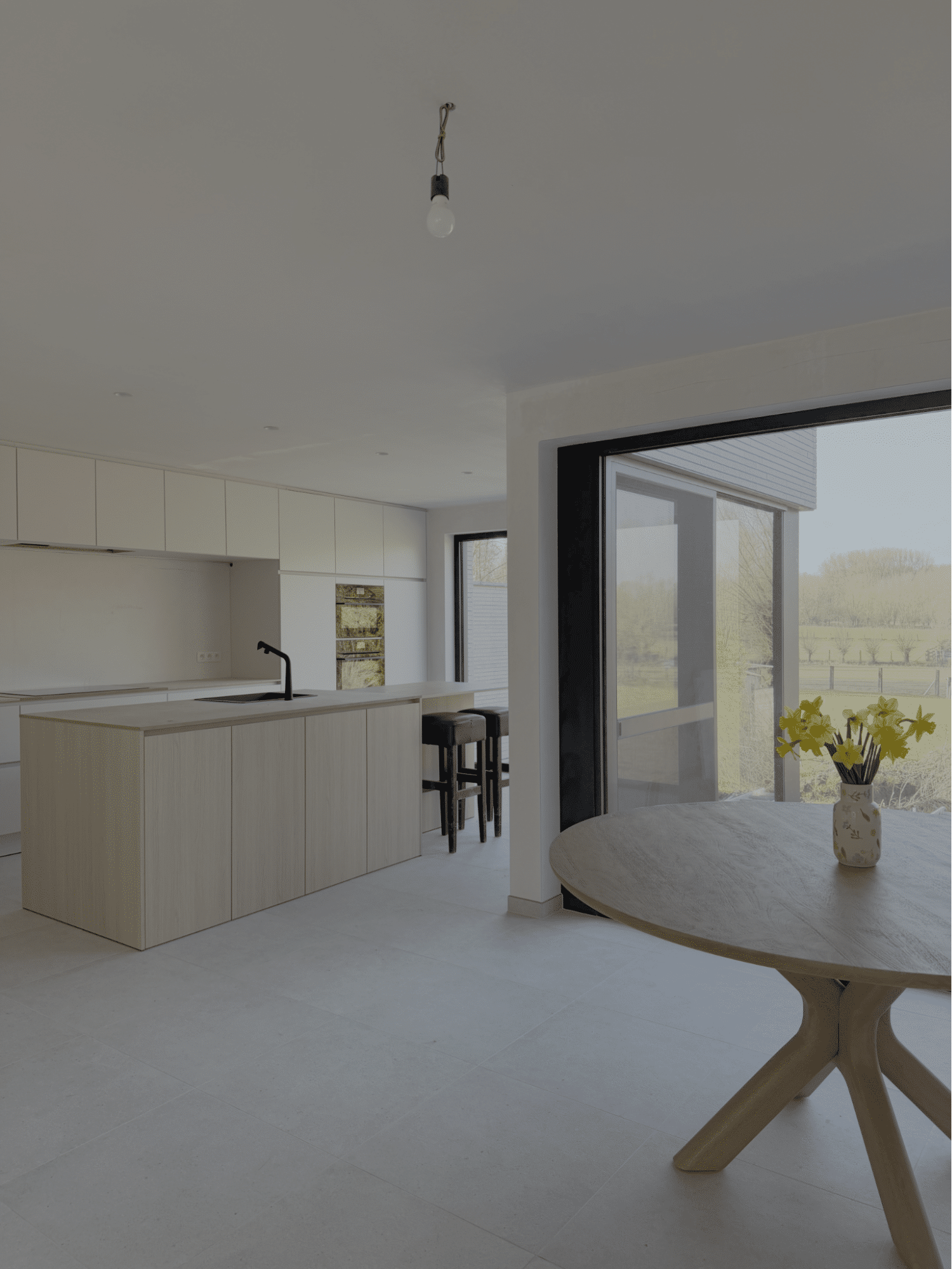 Moderne keuken met keramische vloer en grote raampartij in een nieuwbouwwoning van NB-Projects
