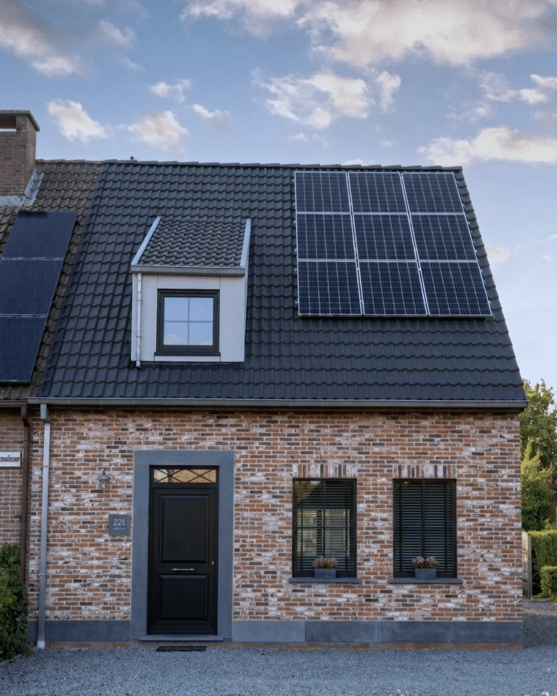Landelijke woning met zwart pannendak, zonnepanelen, dakkapel en zwarte voordeur
