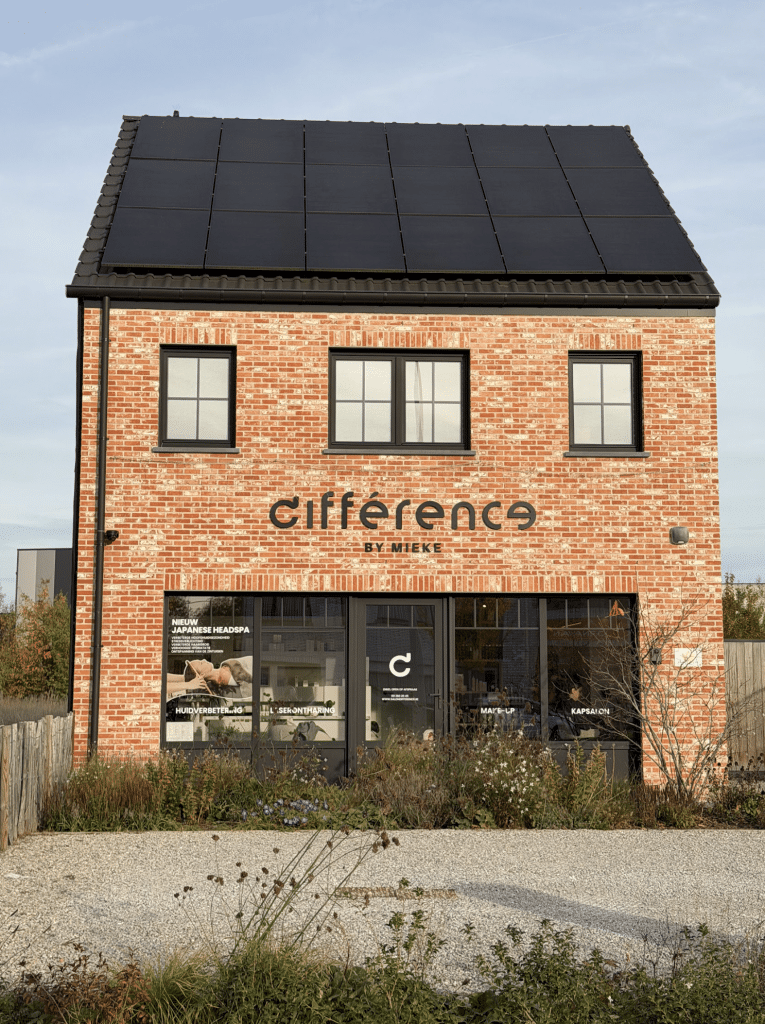 Bakstenen bedrijfspand met woonverdieping, zonnepanelen en winkelpui op het gelijkvloers