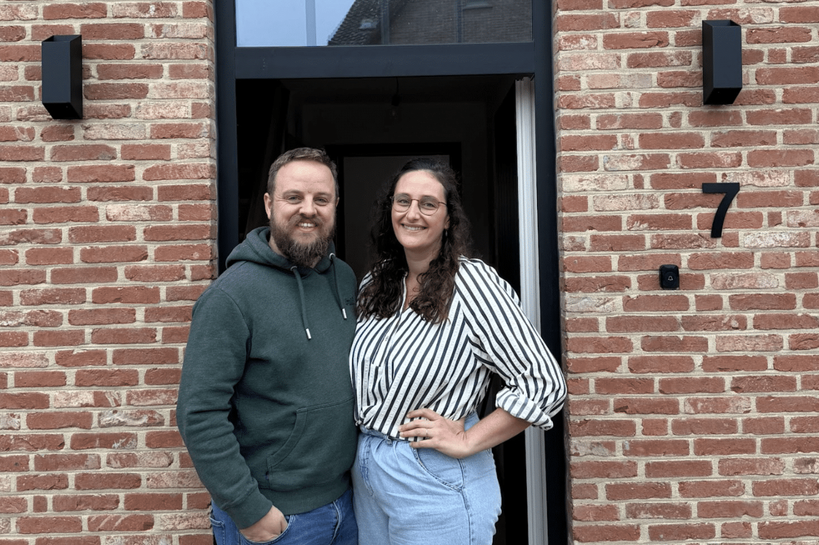 Trots koppel voor de voordeur van hun afgewerkte nieuwbouwwoning na de sleuteloverdracht