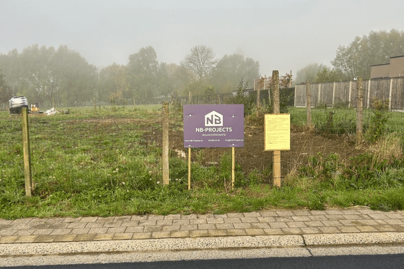 Bouwgrond met bord van NB-Projects, klaar om er een nieuwbouwwoning op te bouwen