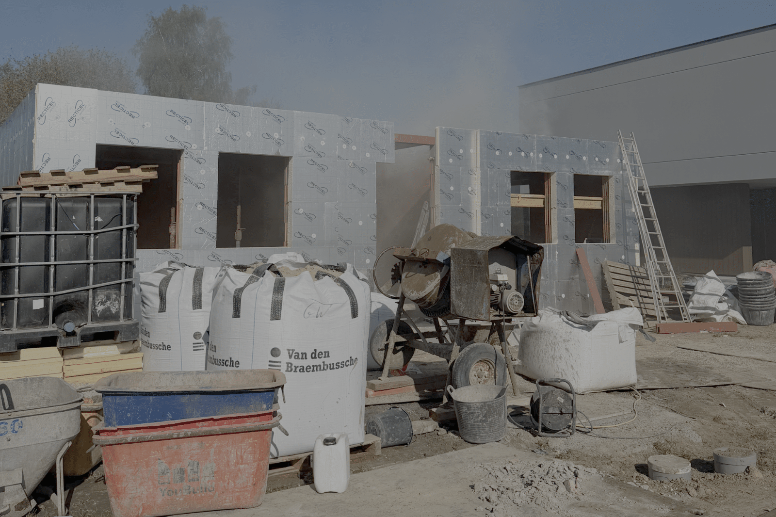 Nieuwbouwwoning in aanbouw met geplaatste gevelisolatie en bouwmaterialen op de werf